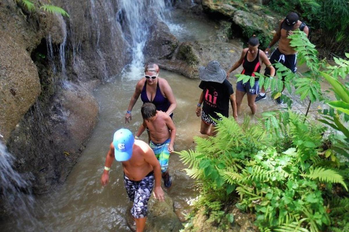 un gruppo di persone in piedi nell'acqua vicino a una cascata