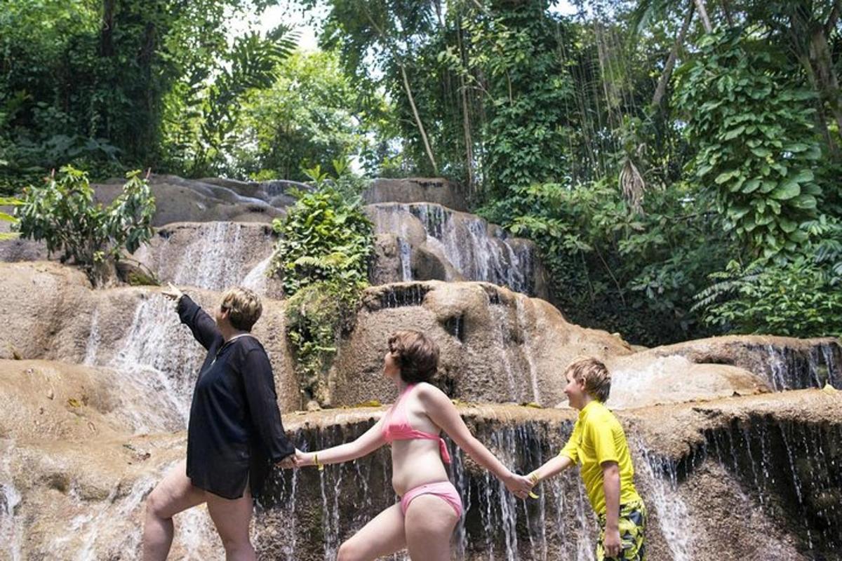 un gruppo di persone in piedi davanti a una cascata