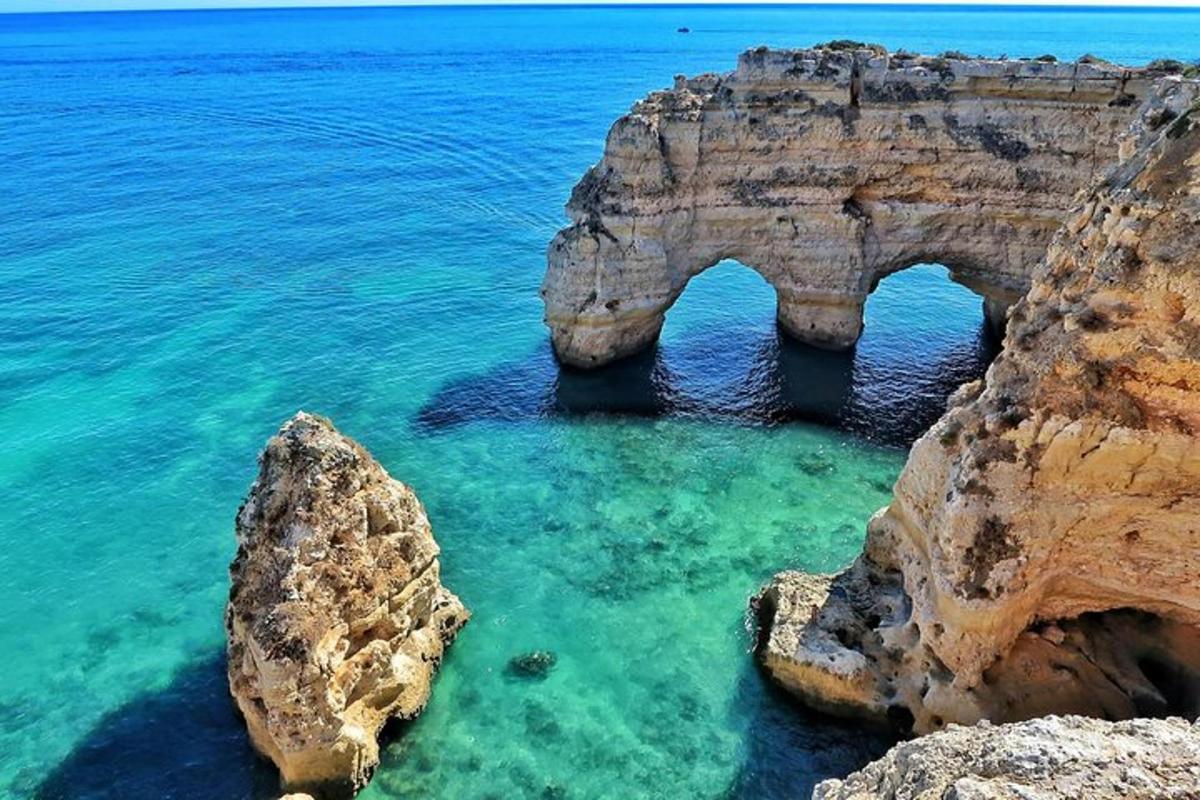 um arco no oceano com pedras na água