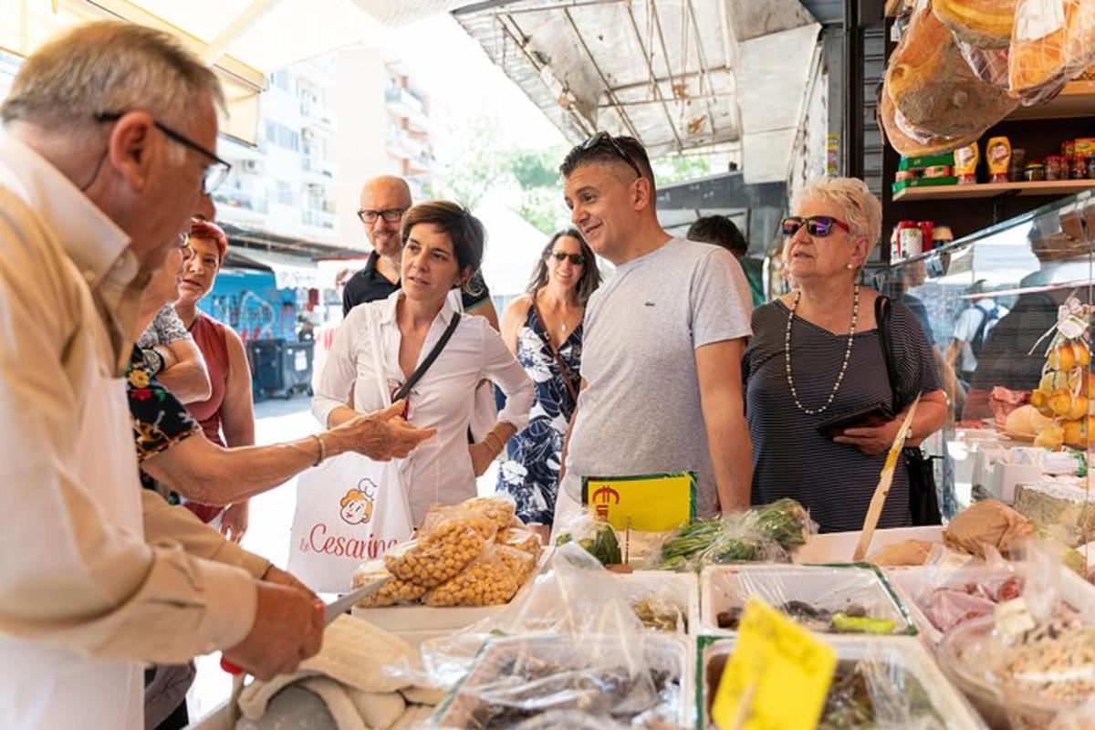 a group of people standing around a table with food
