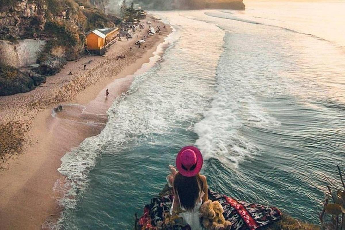 žena sedící na pláži a dívající se na oceán