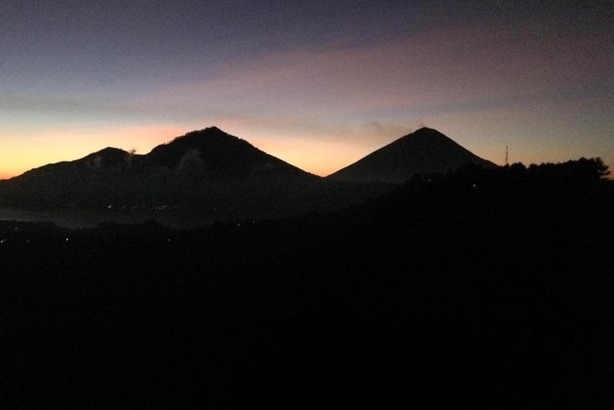 un gruppo di montagne con il tramonto sullo sfondo