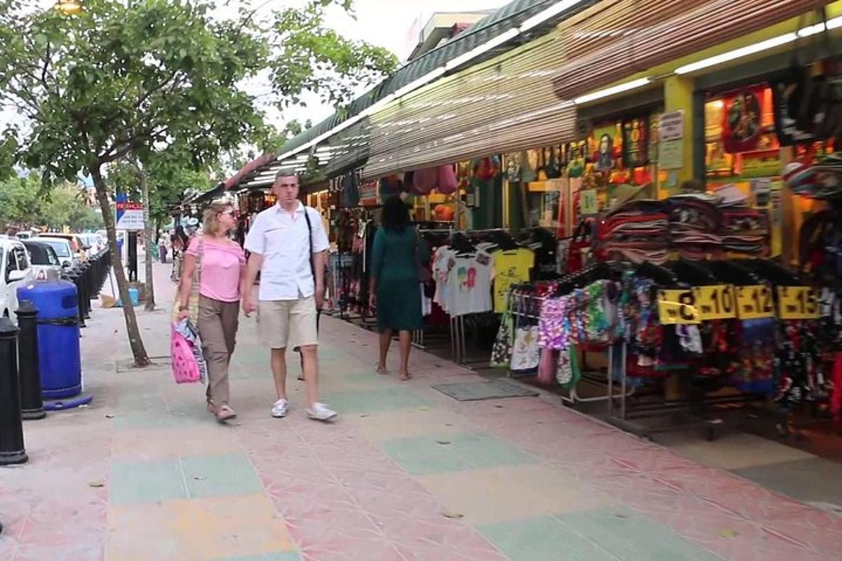 Ein Mann und eine Frau gehen einen Bürgersteig vor einem Markt entlang