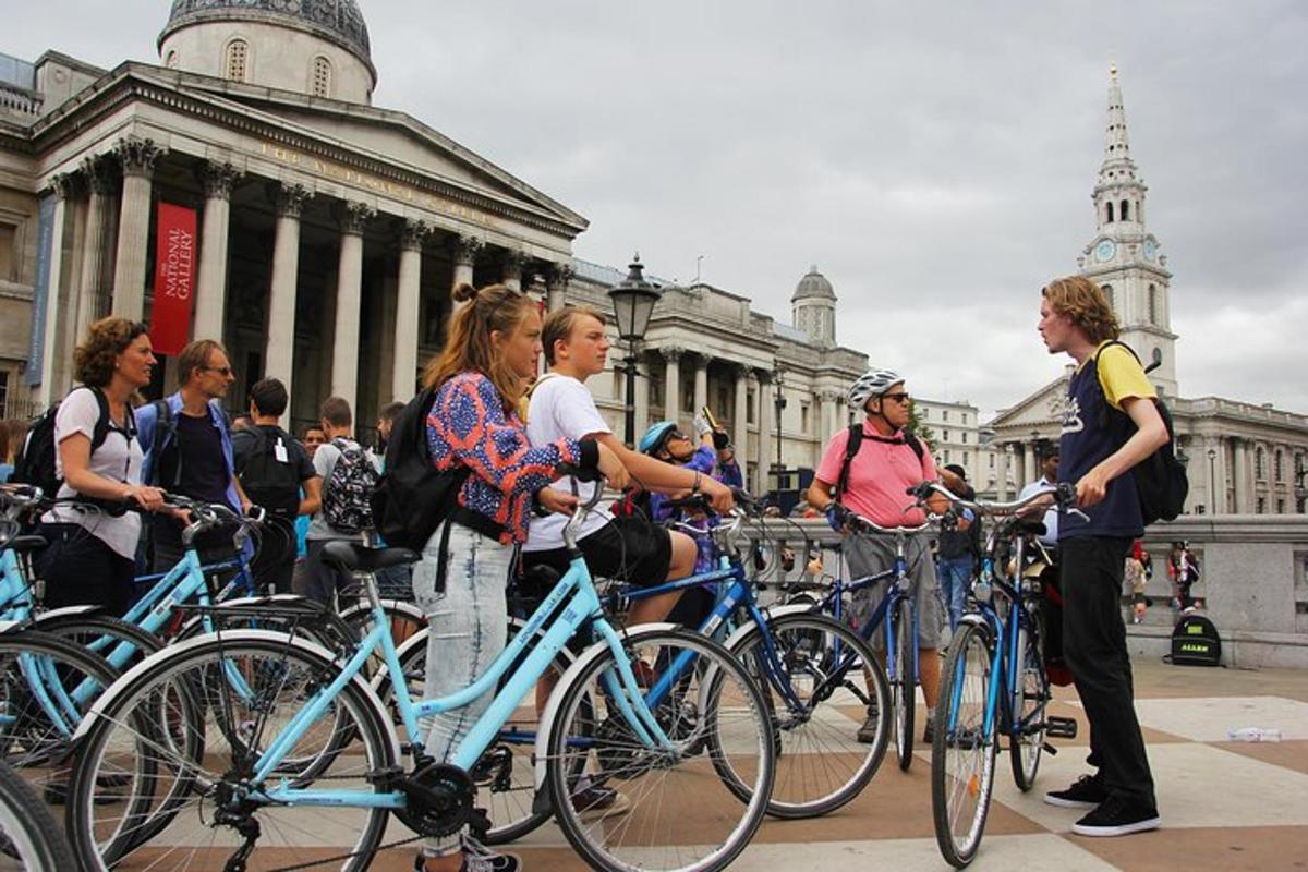 um grupo de pessoas em pé com bicicletas em frente a um prédio