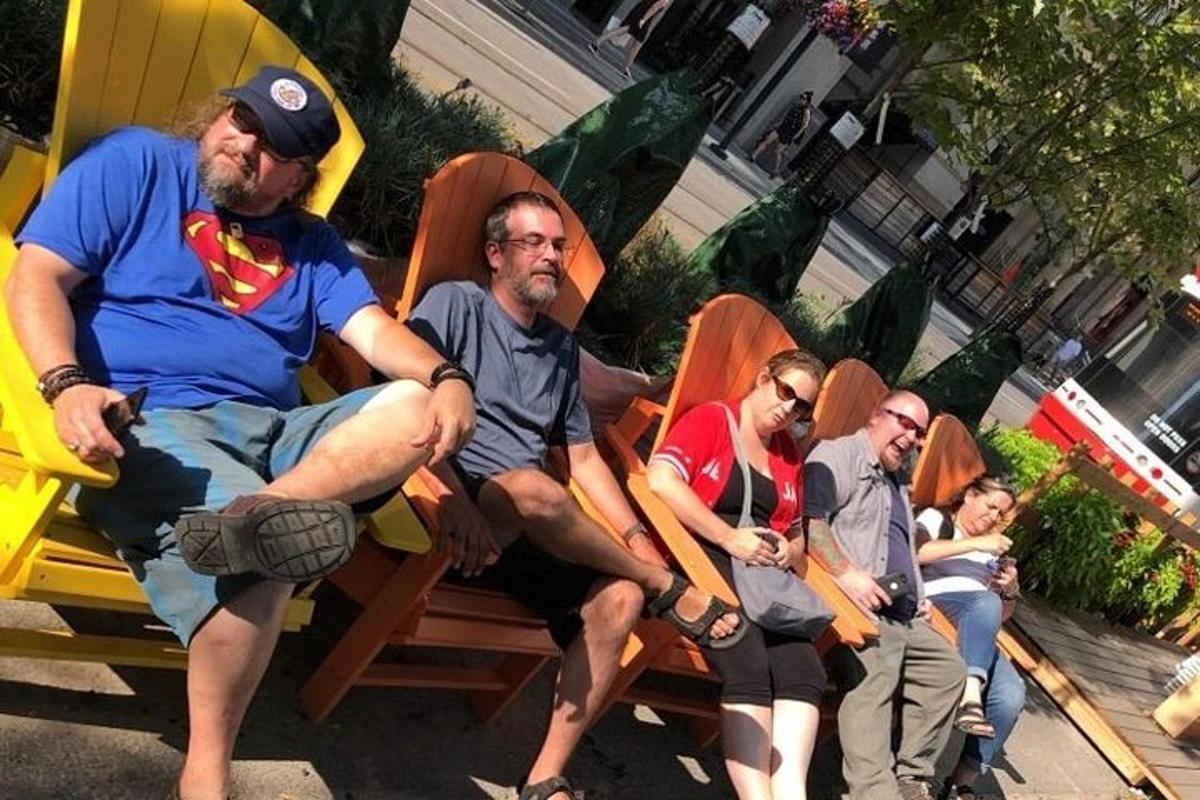 um grupo de pessoas sentadas em cadeiras em um banco