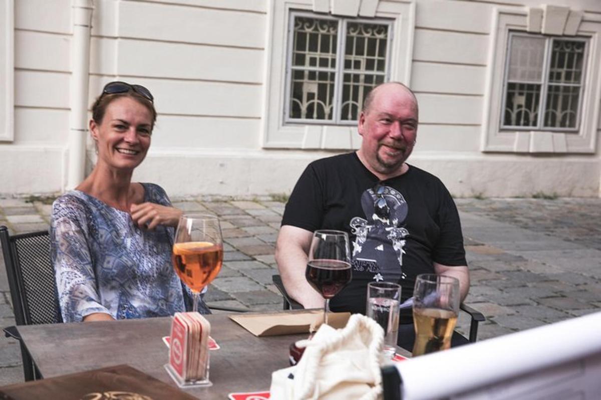 en mann og en kvinne som sitter ved et bord med vinglass