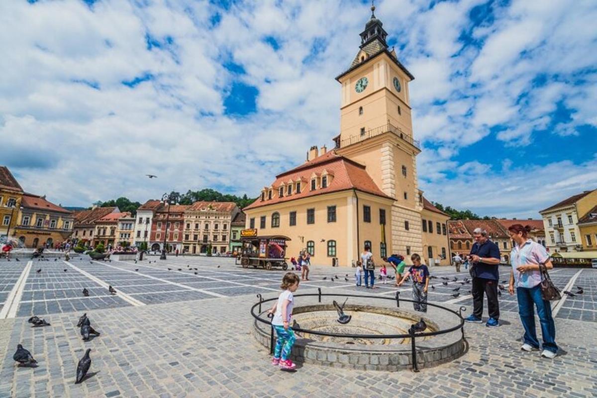 a group of people standing in a plaza with a clock tower
