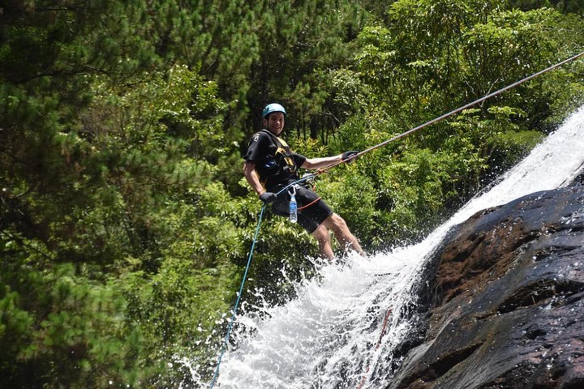 a man holding onto a rope while water skiing on a waterfall