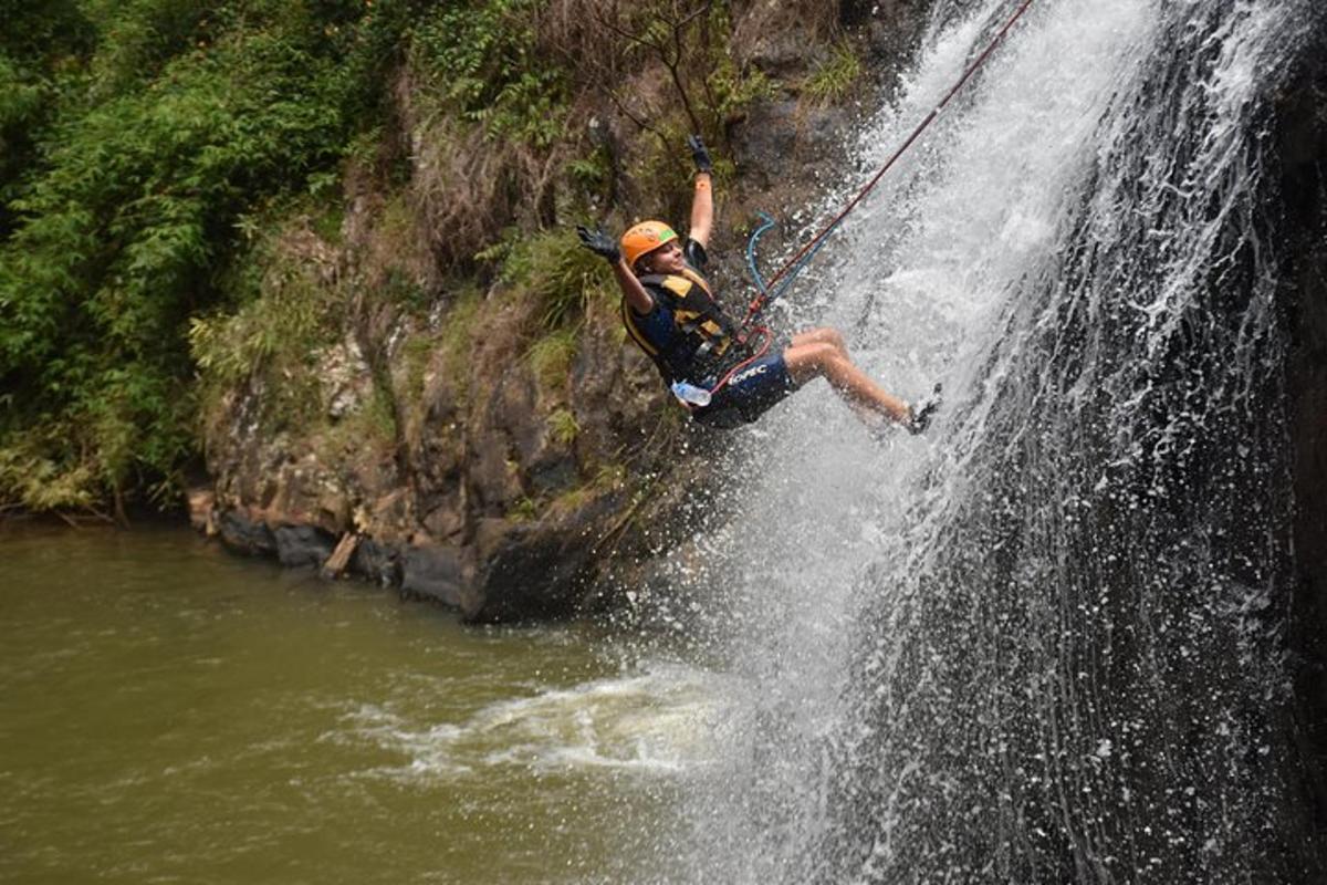 a man is rappelling off of a waterfall