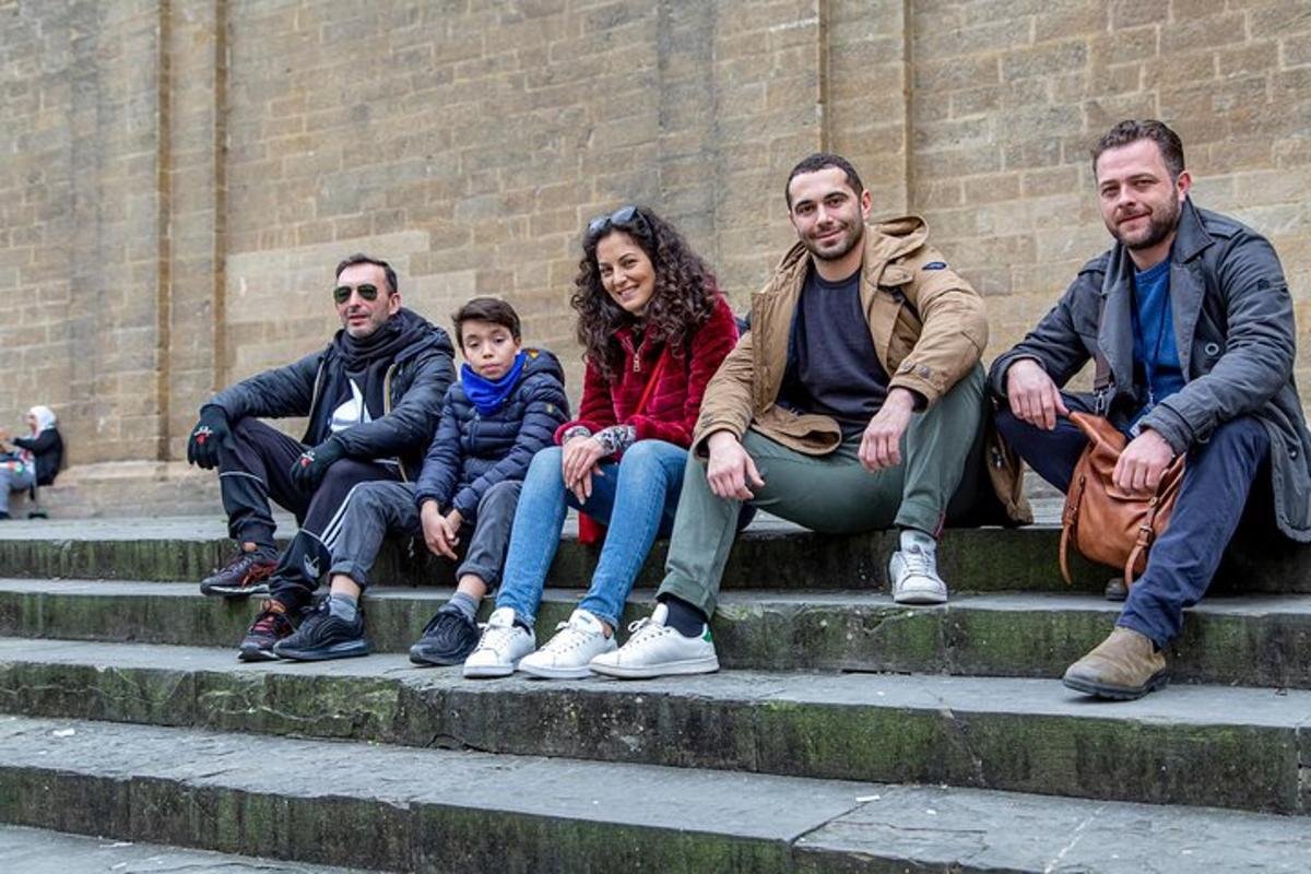 Un grupo de personas sentadas en los escalones frente a un edificio.