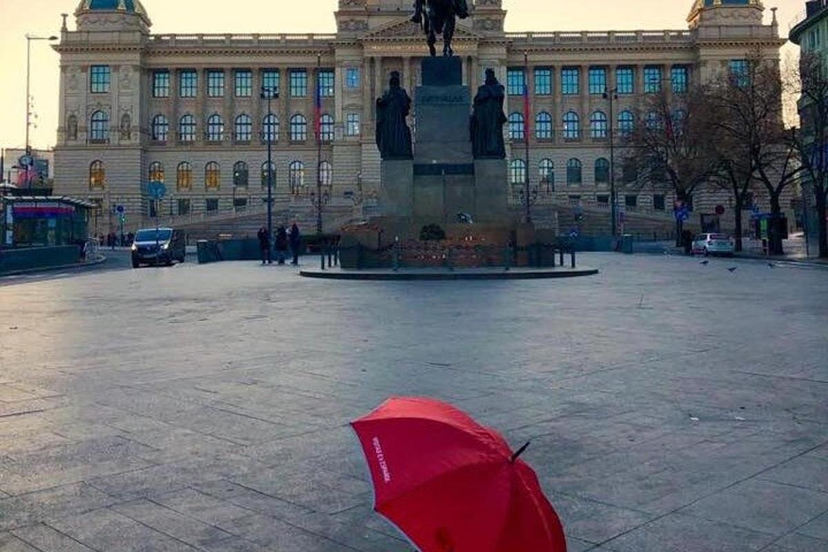 un ombrello rosso appoggiato davanti a un grande edificio