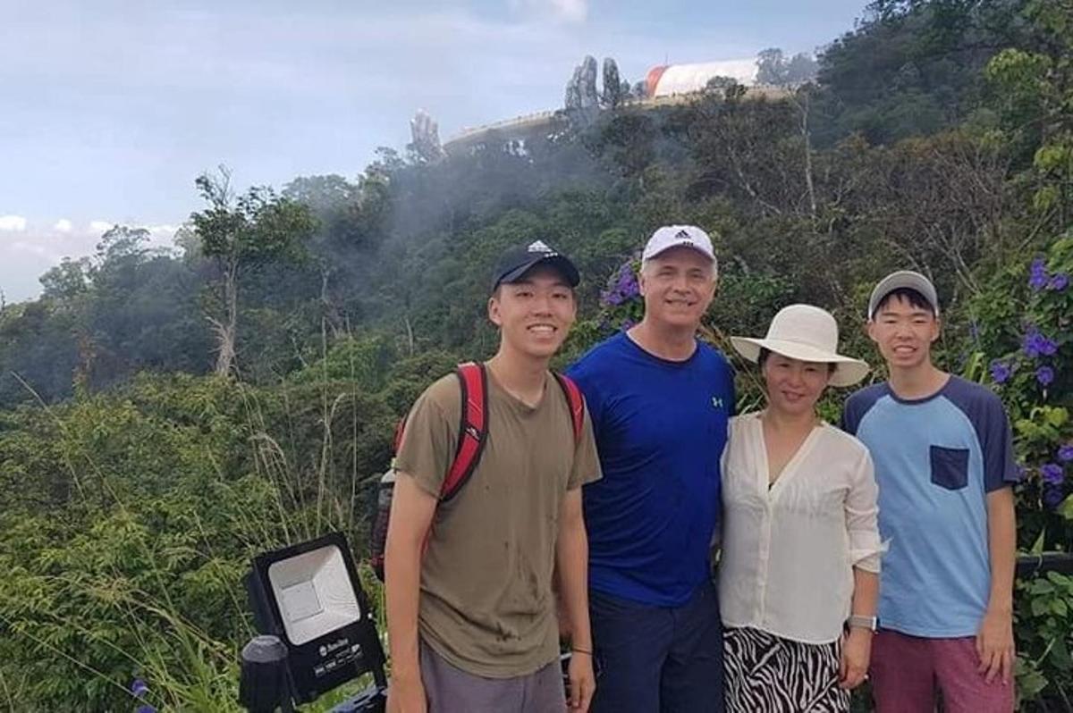 um grupo de pessoas em pé em frente a uma montanha