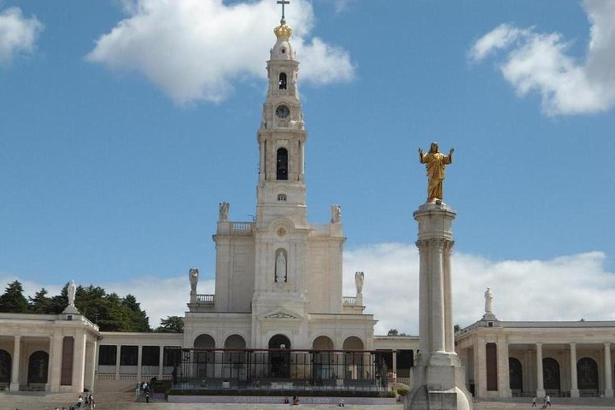 um grande edifício branco com uma estátua na frente