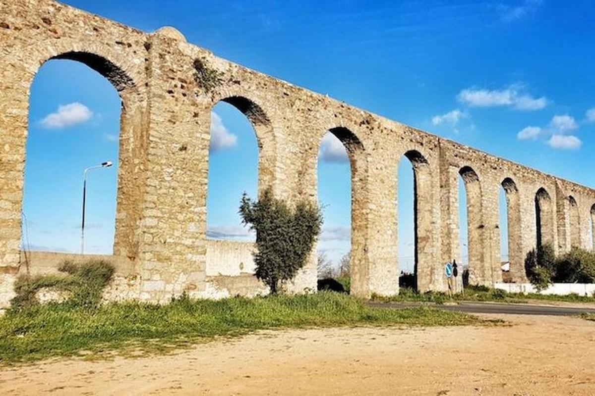 جسر حجري قديم ذو أقواس على جانب الطريق