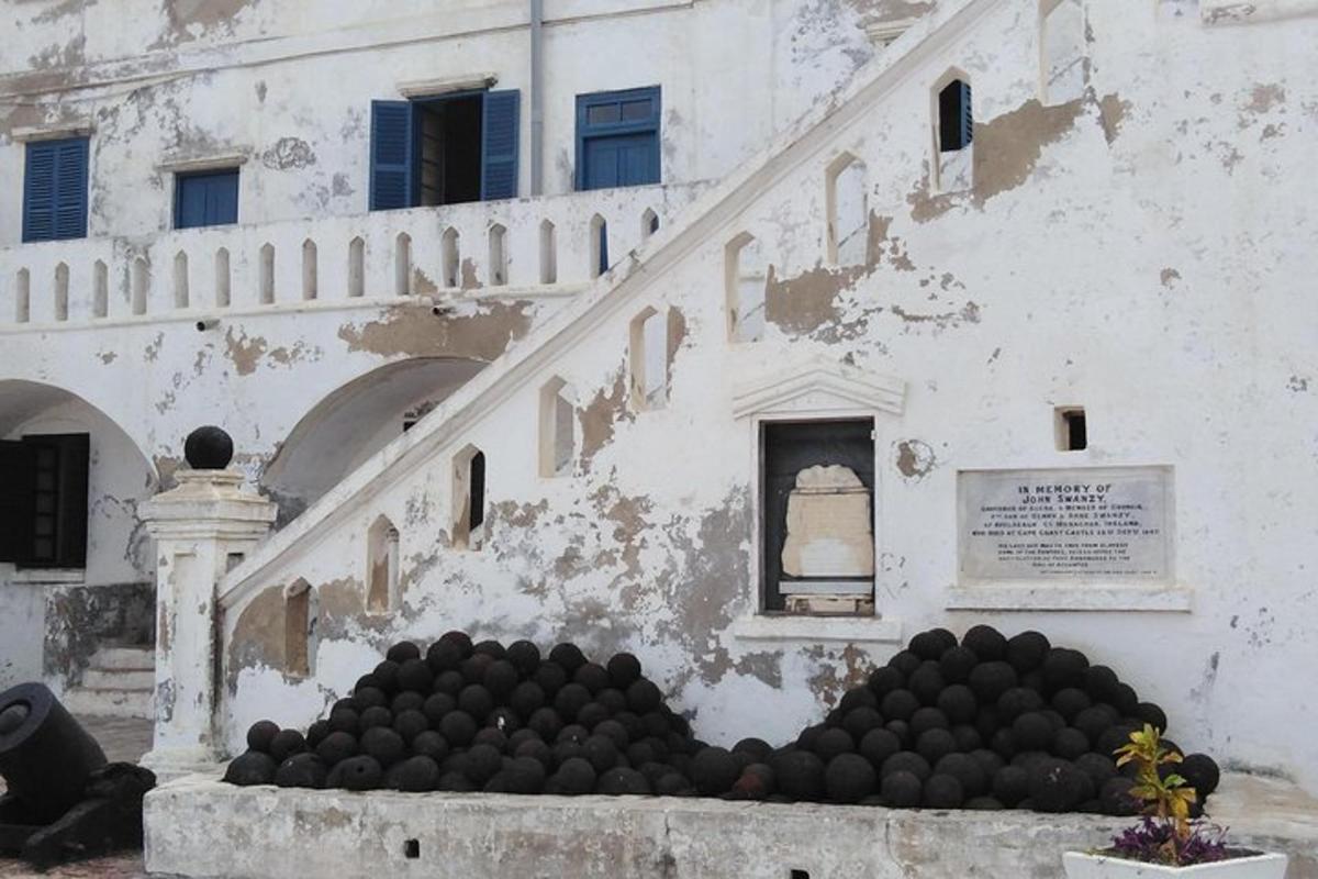 un edificio con una pila di palline nere di fronte
