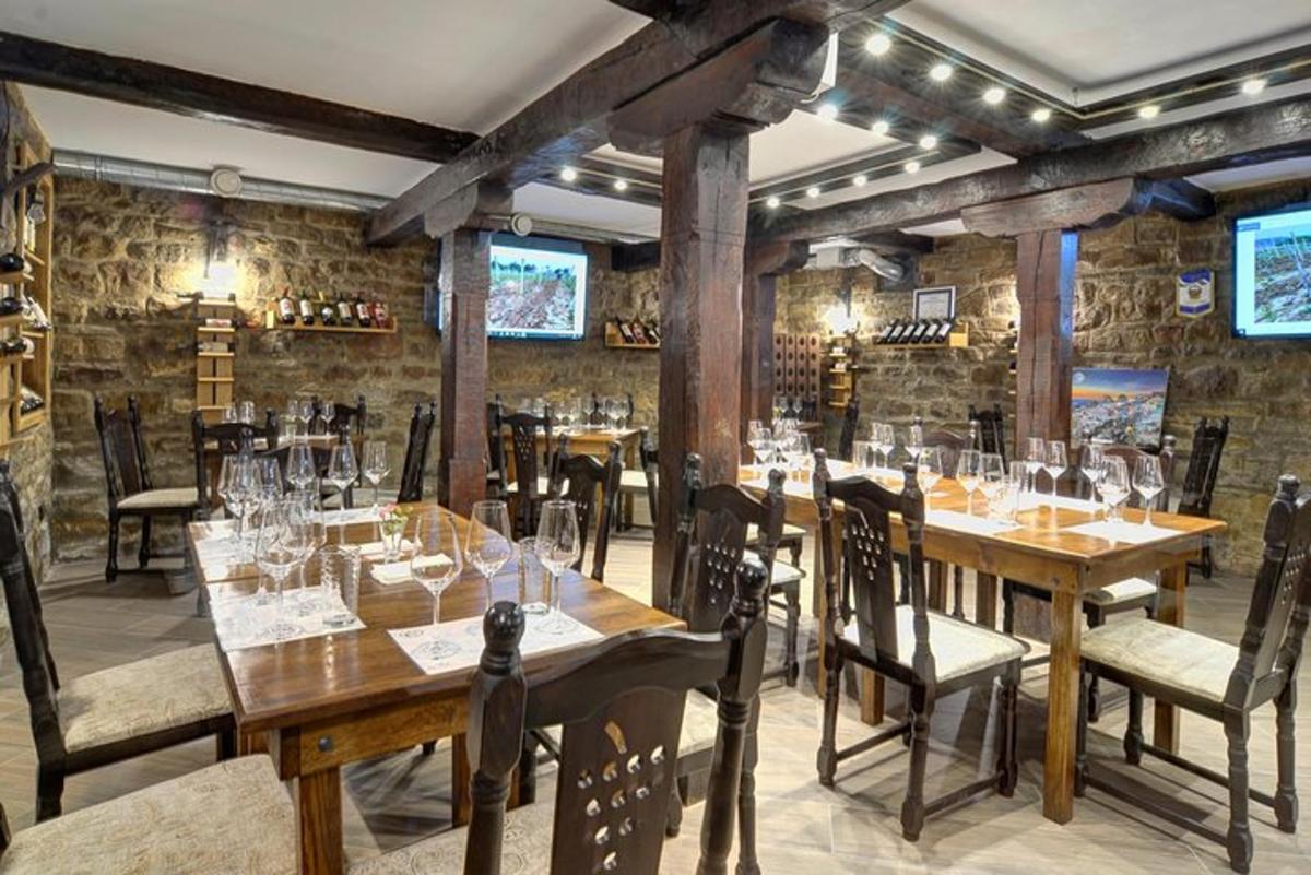 a restaurant with wooden tables and chairs and brick walls