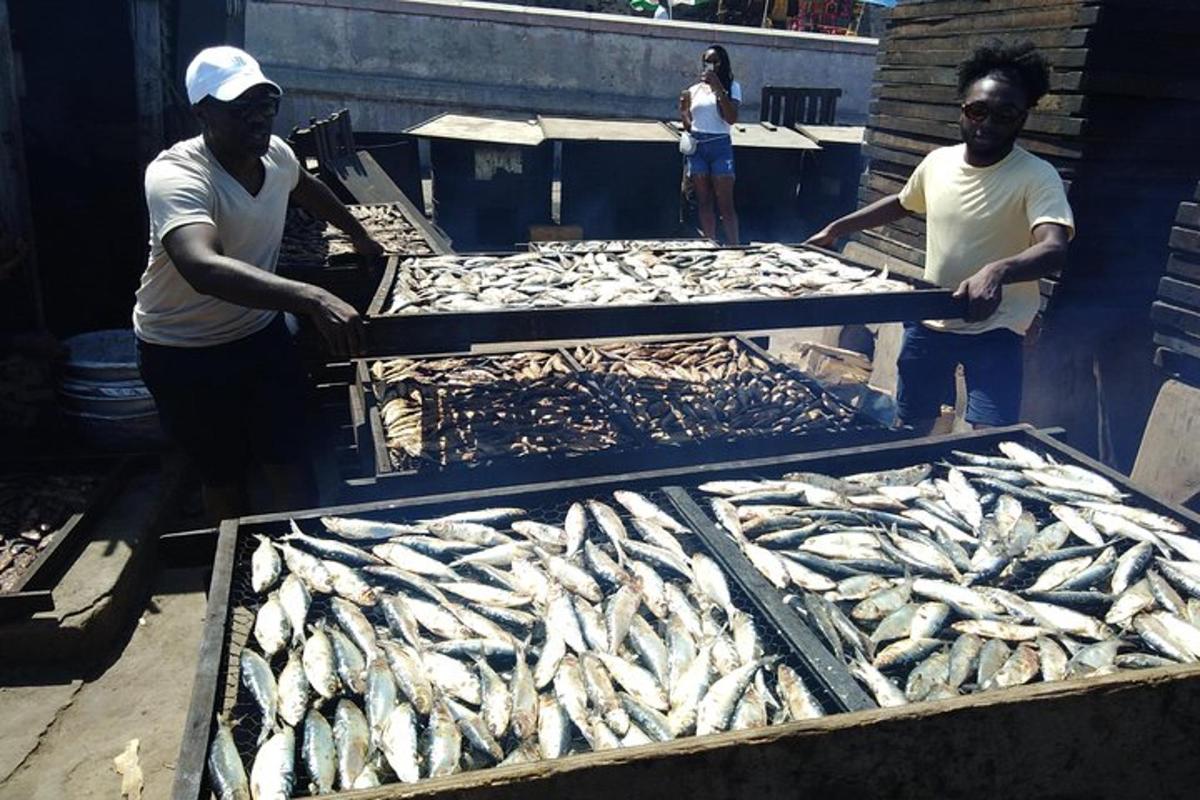 dua orang lelaki sedang menyediakan ikan di atas dulang di sebuah pasar