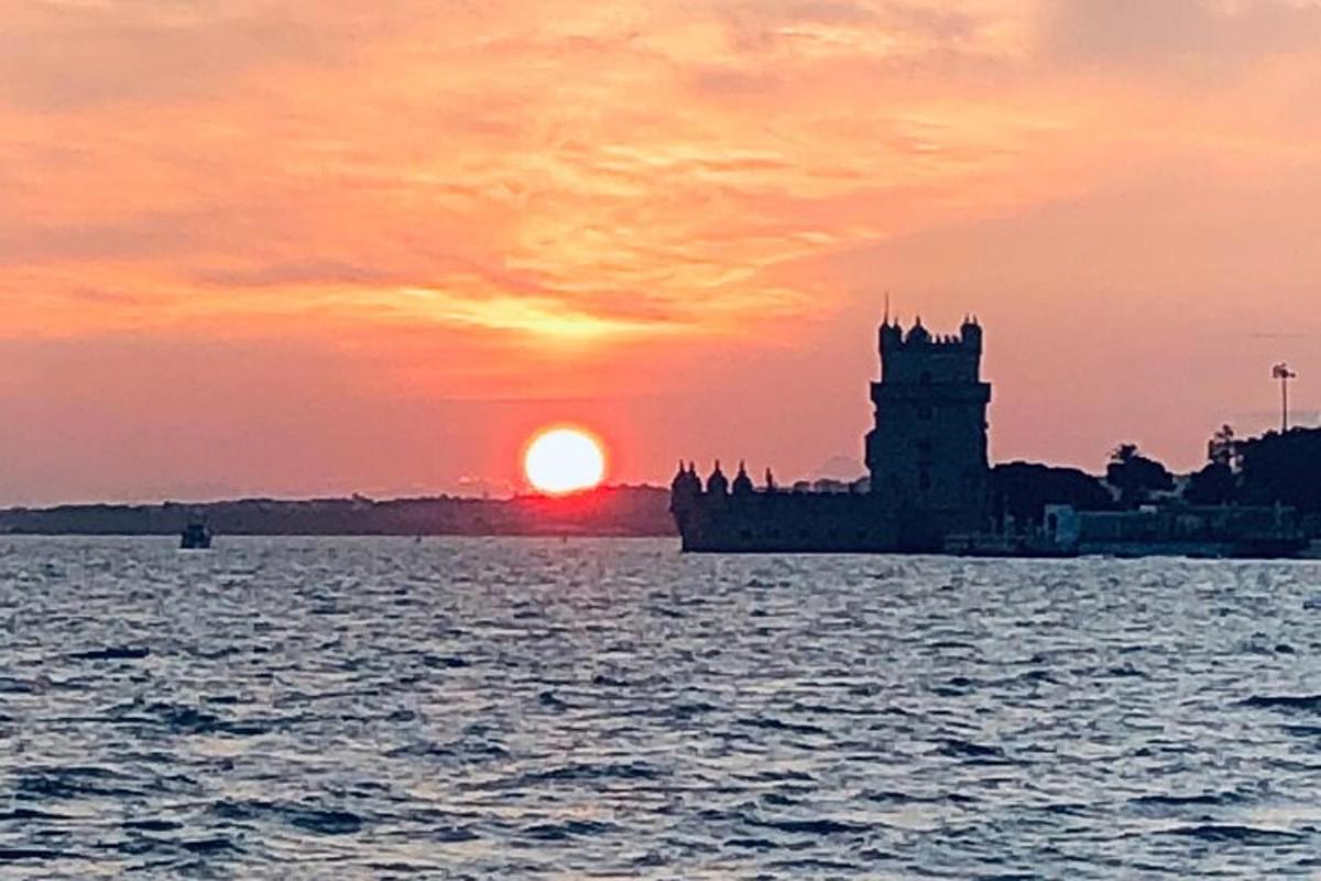 a sunset over a body of water with a clock tower