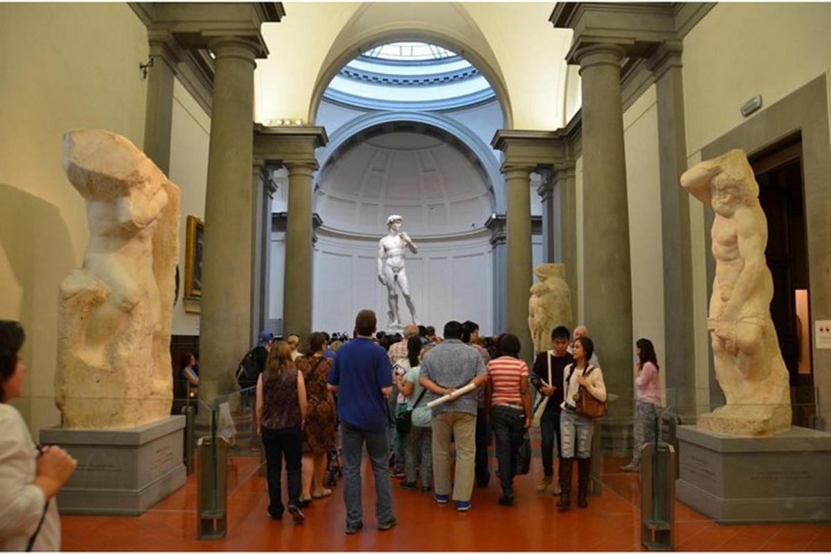 un gruppo di persone che guardano le statue in un museo