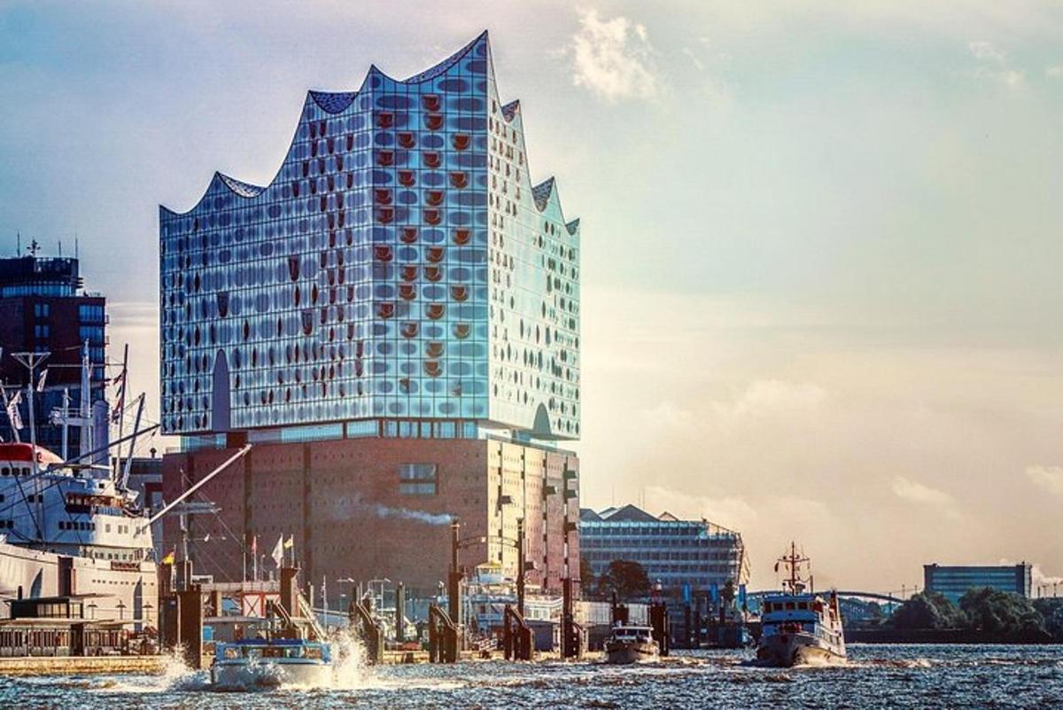 a tall building with a geometric design on it next to the water