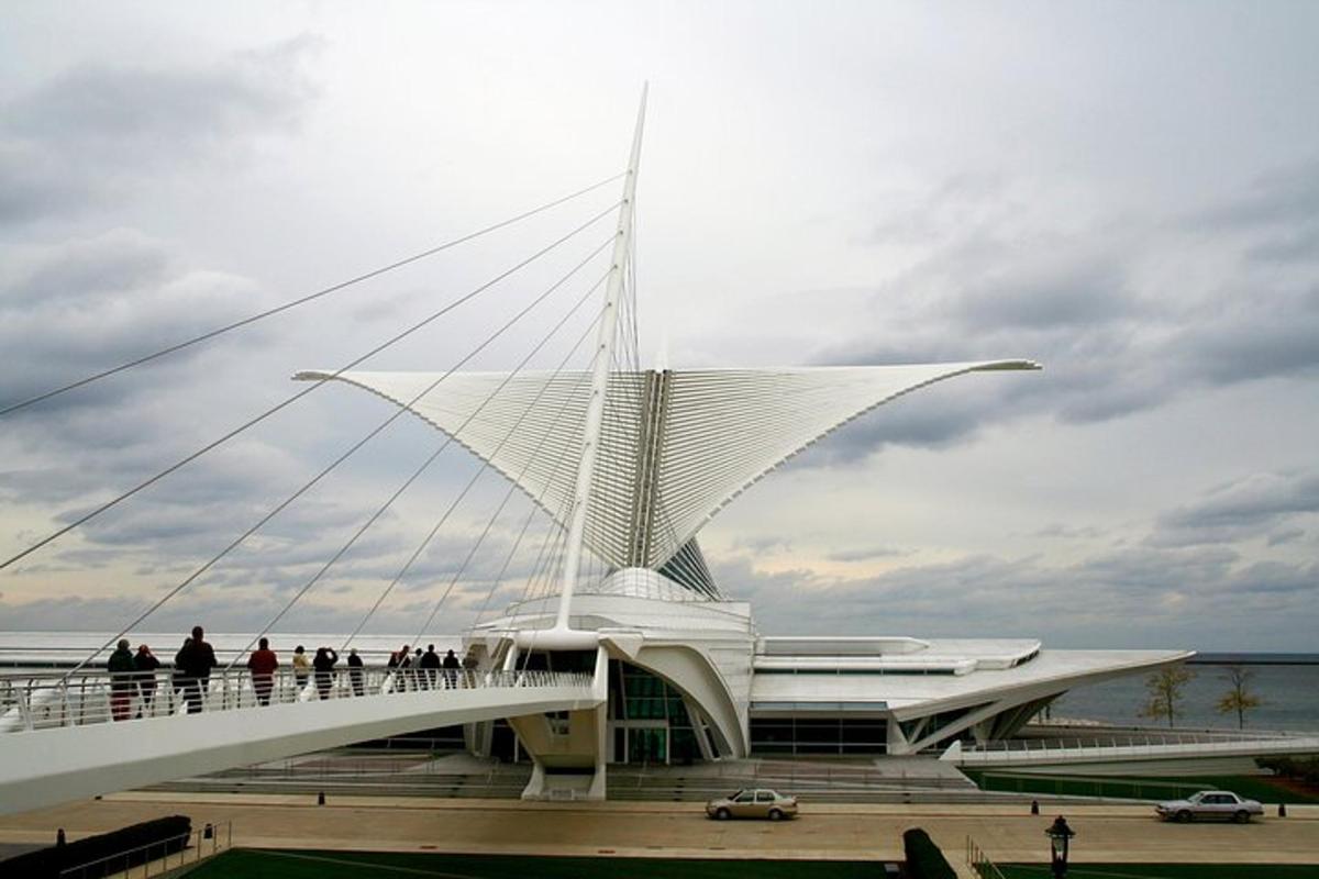 a large white building with people on a bridge