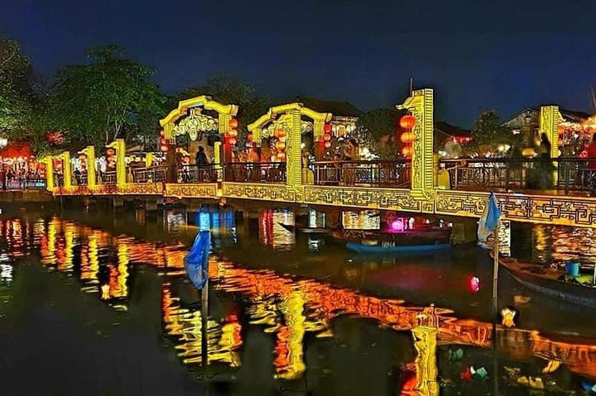 um parque de diversões com uma ponte sobre a água à noite