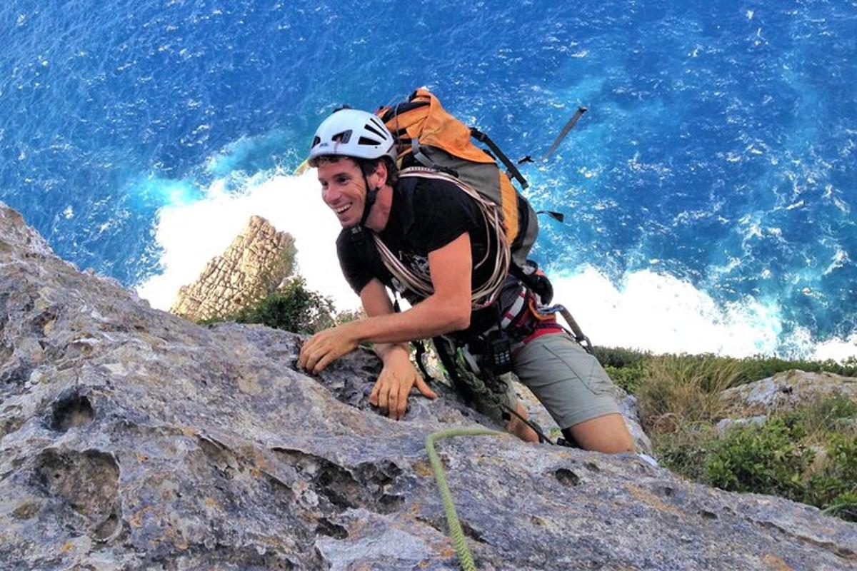 seorang lelaki dengan beg galas mendaki gunung berbatu