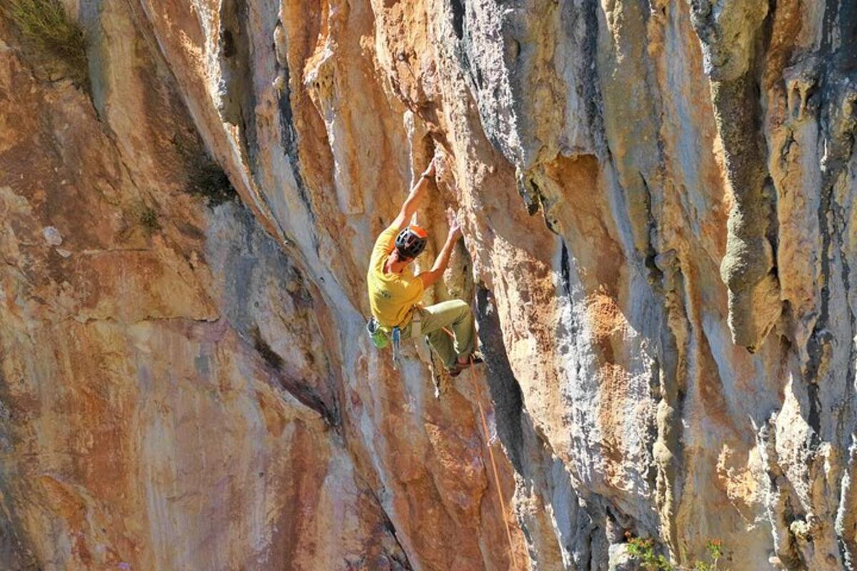 seorang lelaki sedang memanjat batu di atas dinding batu
