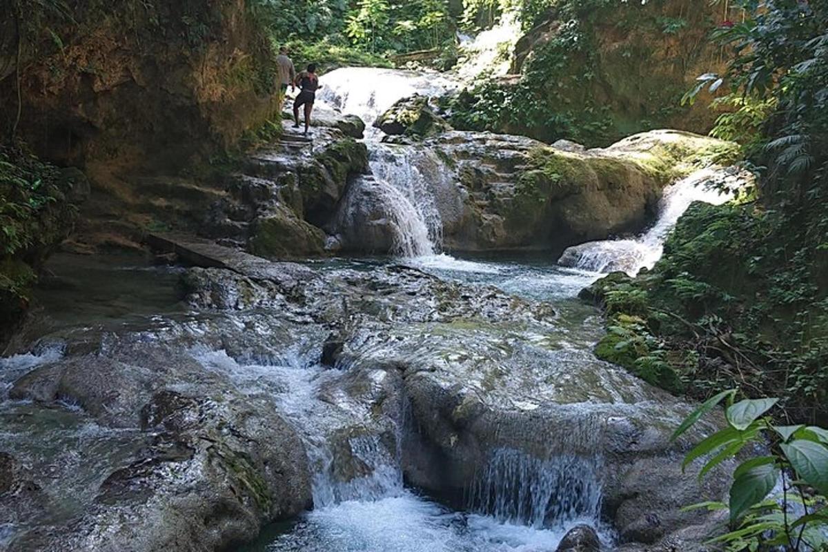ang isang tao ay nakatayo sa isang talon sa isang ilog