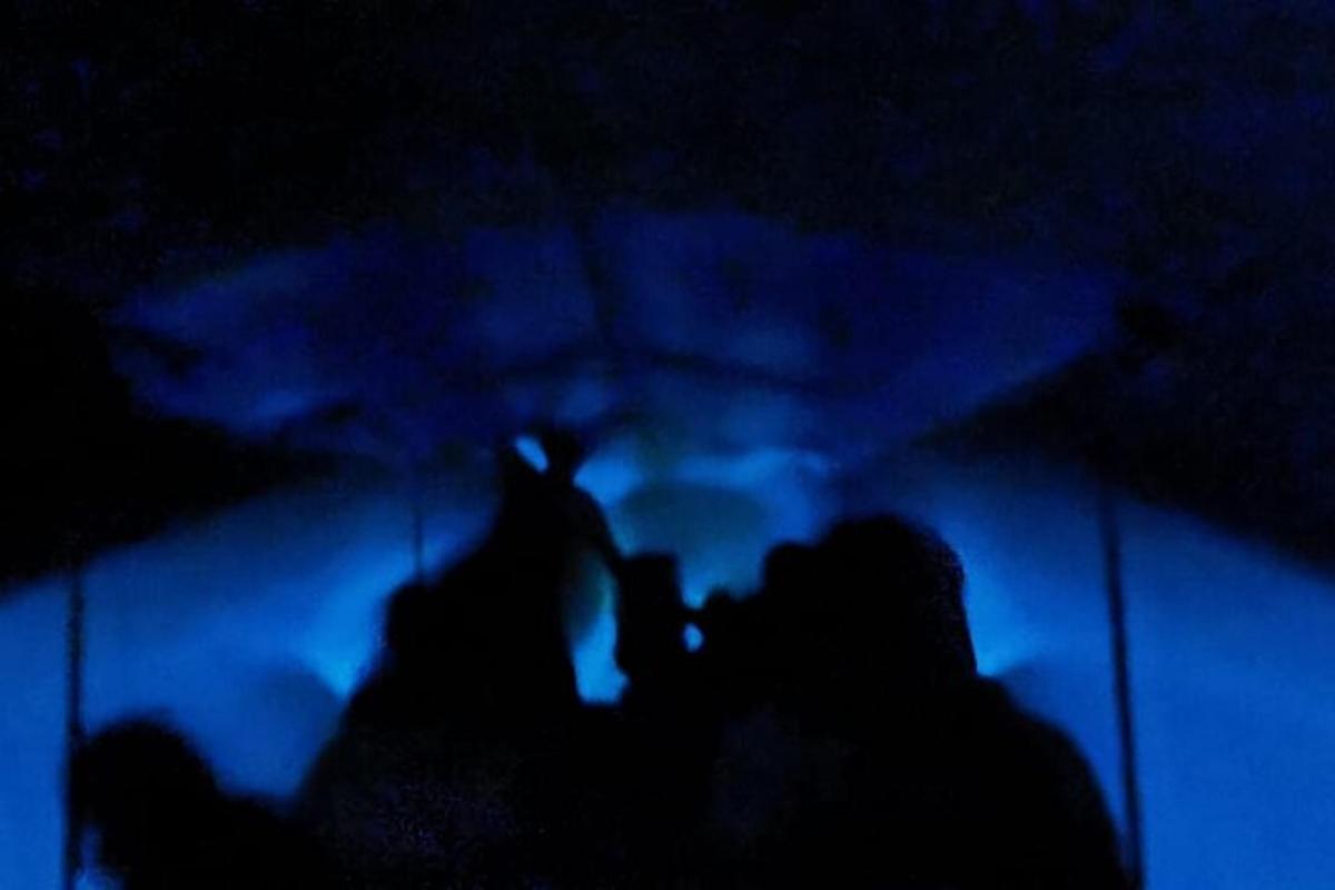a group of people standing in front of a blue stage