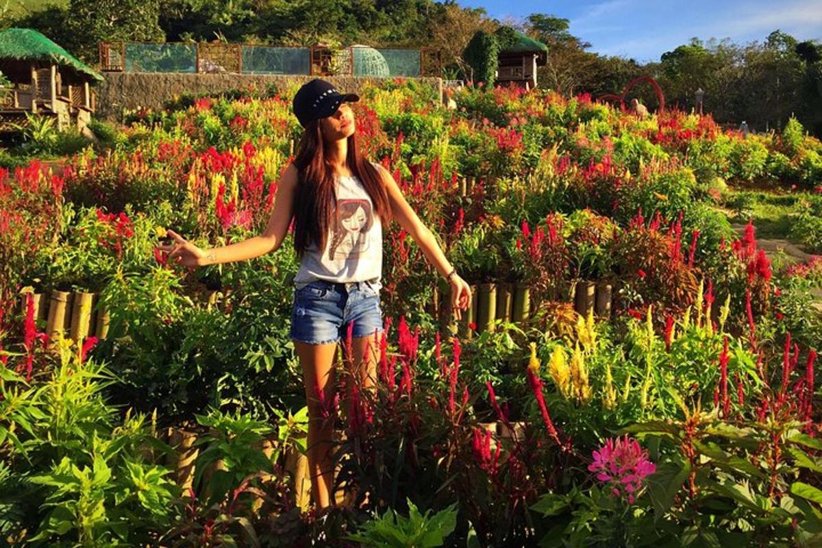 a girl standing in a field of flowers