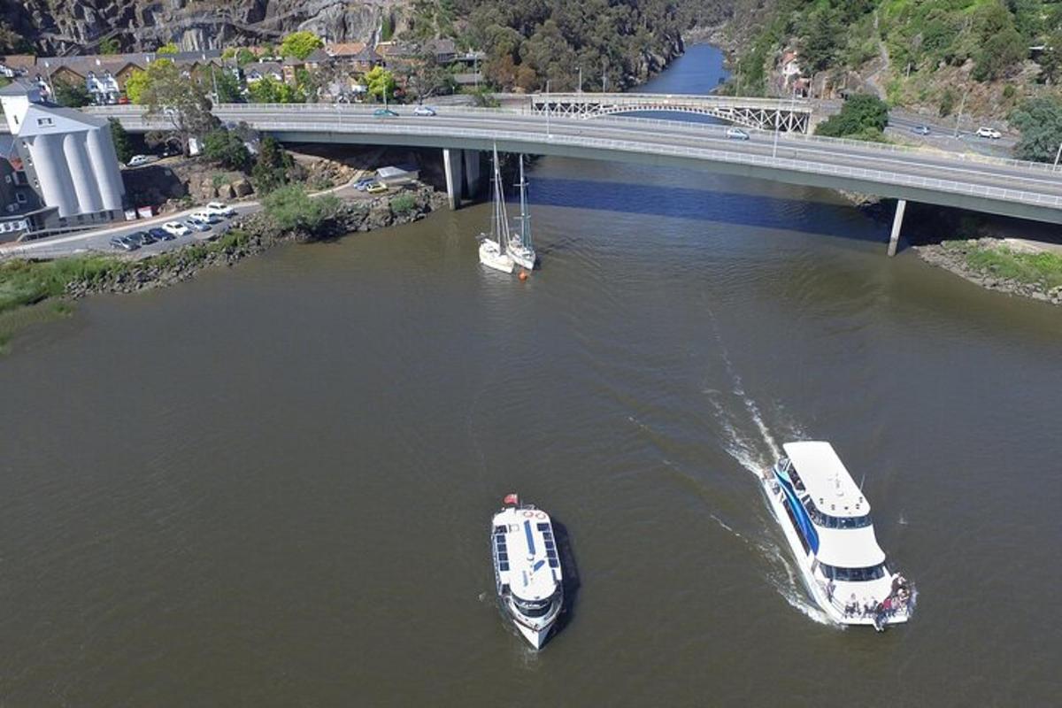 two boats in the water under a bridge