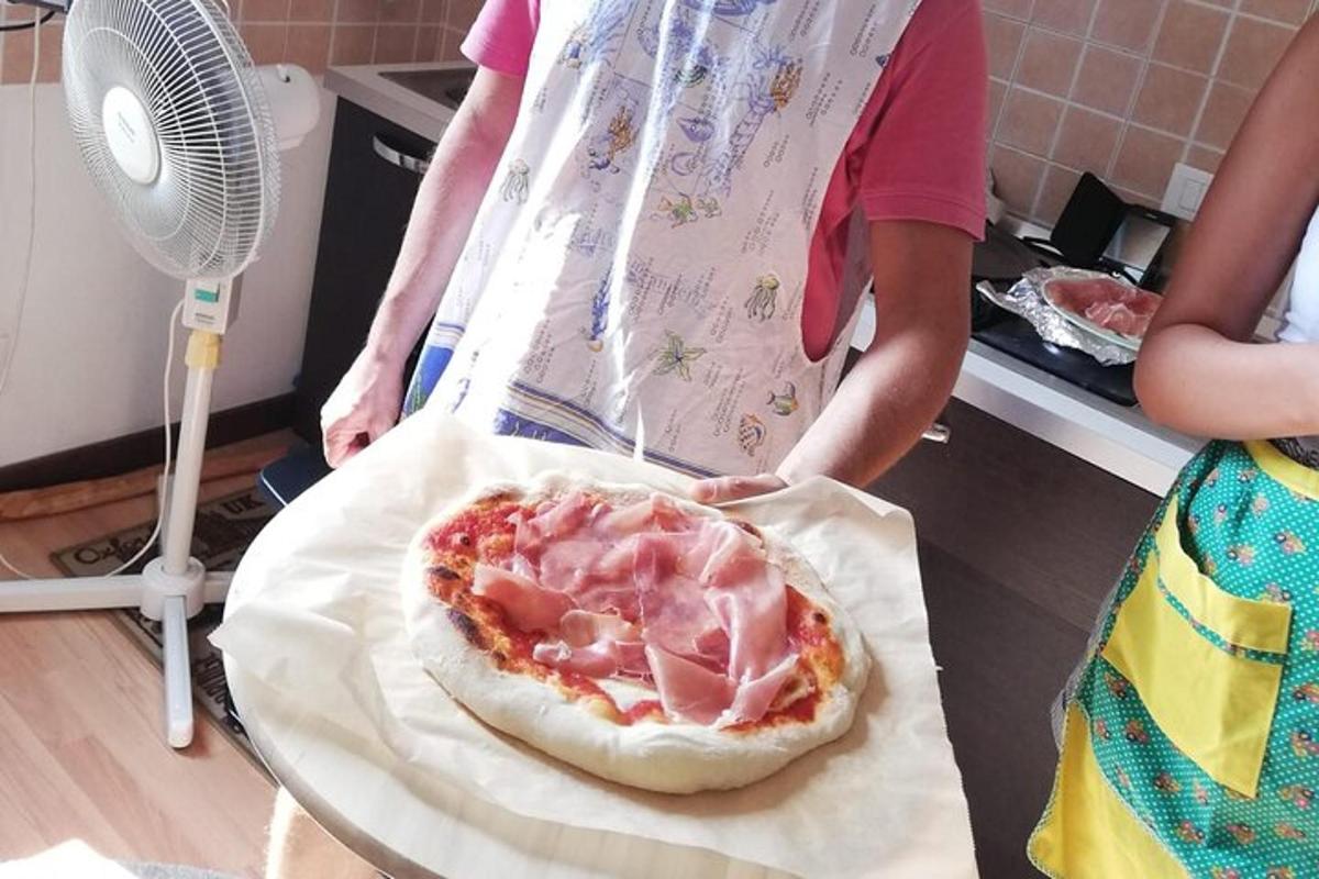 o persoană care ține o pizza pe o masă