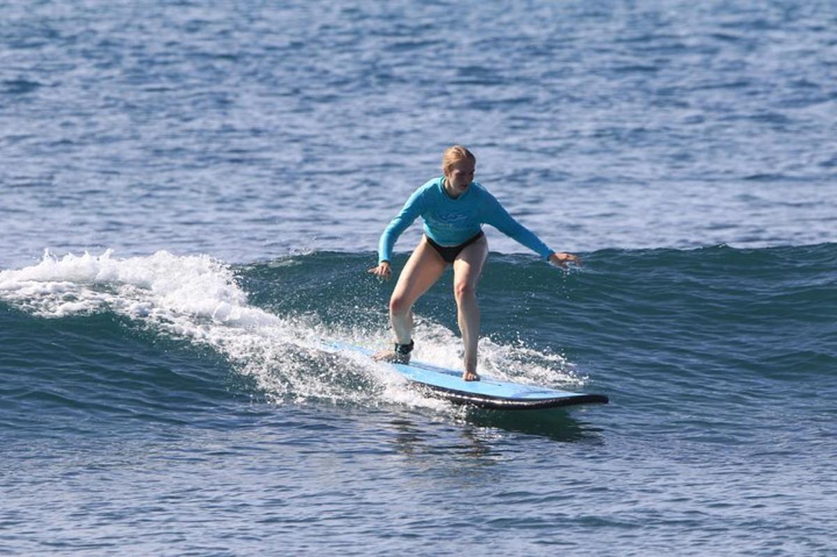 a woman riding a wave on a surfboard in the ocean