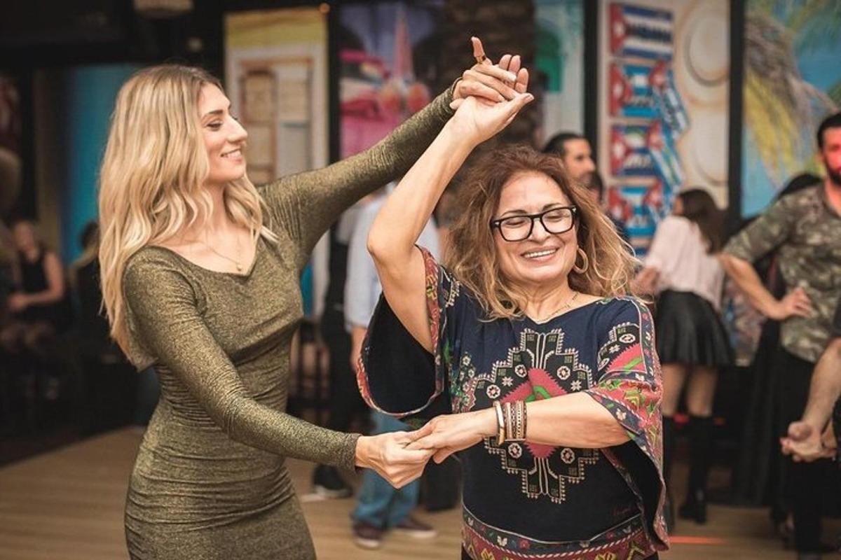 two women standing next to each other with their hands in the air