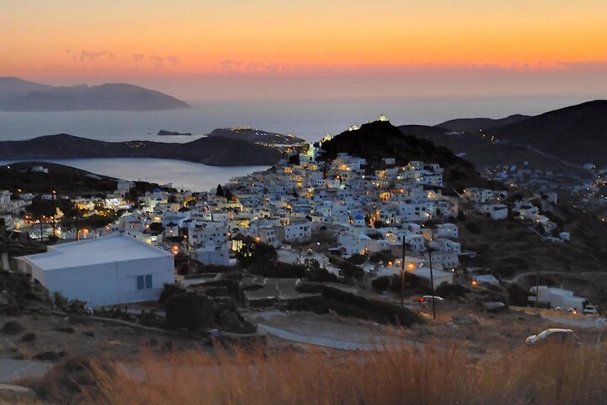 a group of white buildings on a hill at sunset