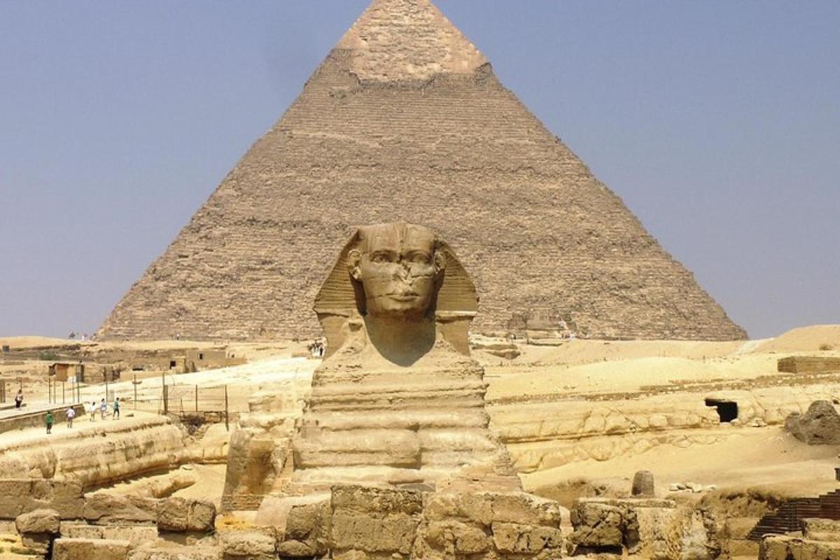 una grande statua di fronte a una piramide