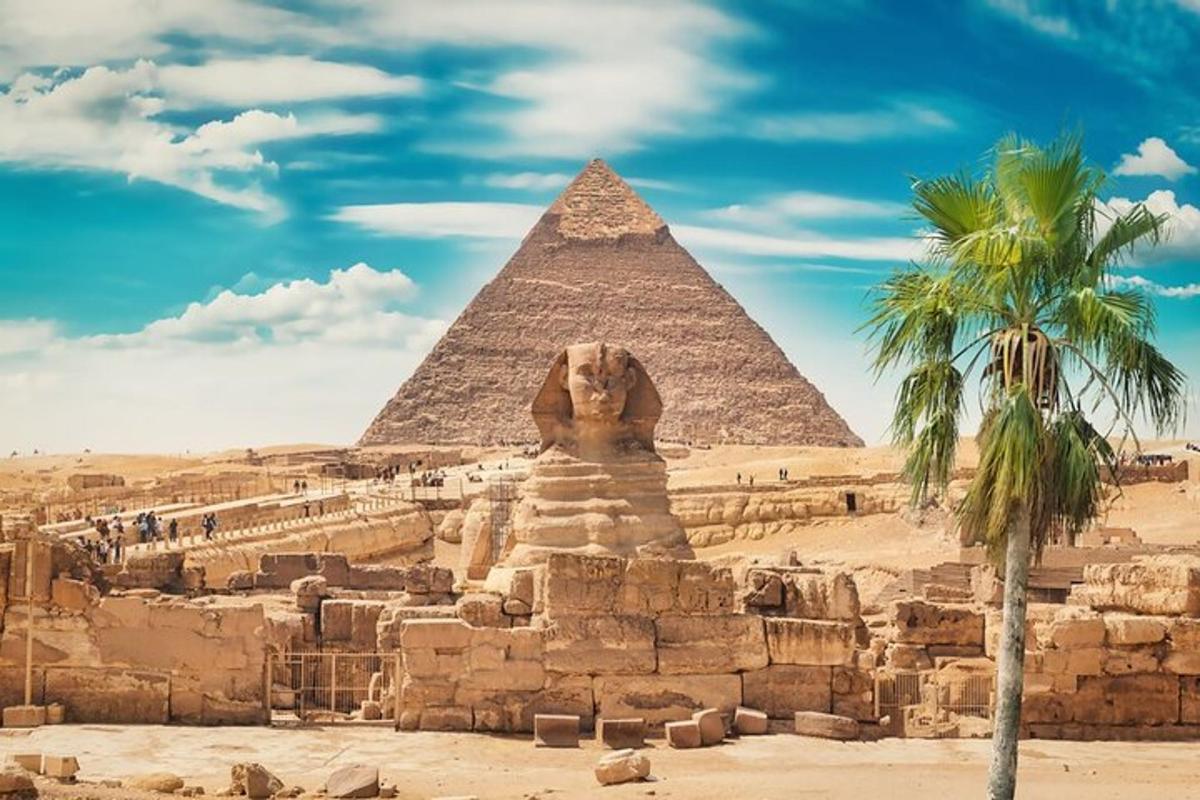 en pyramide og en løvestatue foran et palmetre