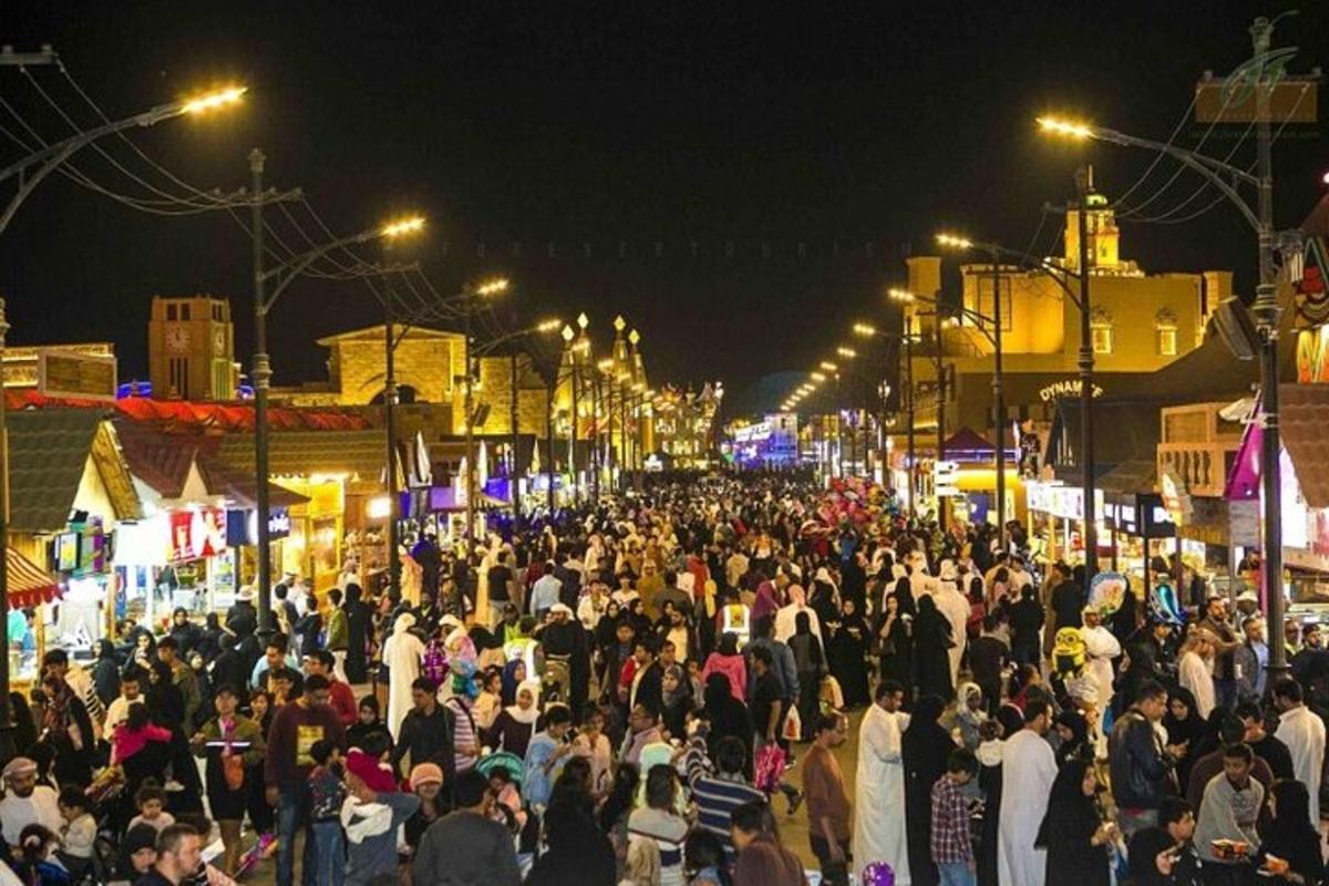 a crowd of people walking down a street at night