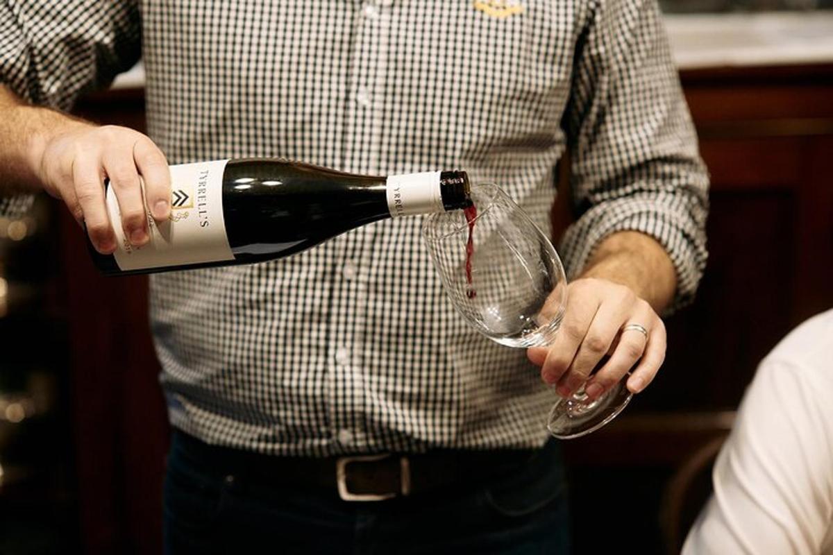 a man pouring a bottle of wine into a wine glass