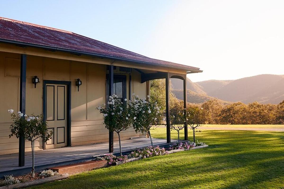 a house with a grass yard next to a building