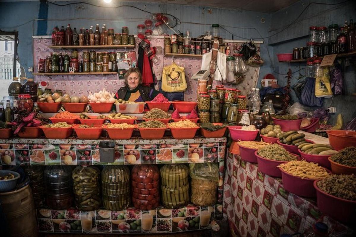 egy nő egy élelmiszer-stand mögött áll a piacon