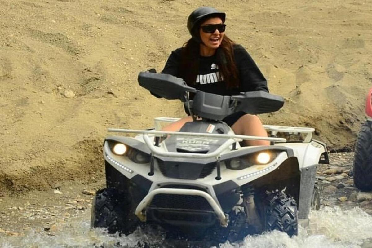 una donna che guida un quad attraverso l'acqua