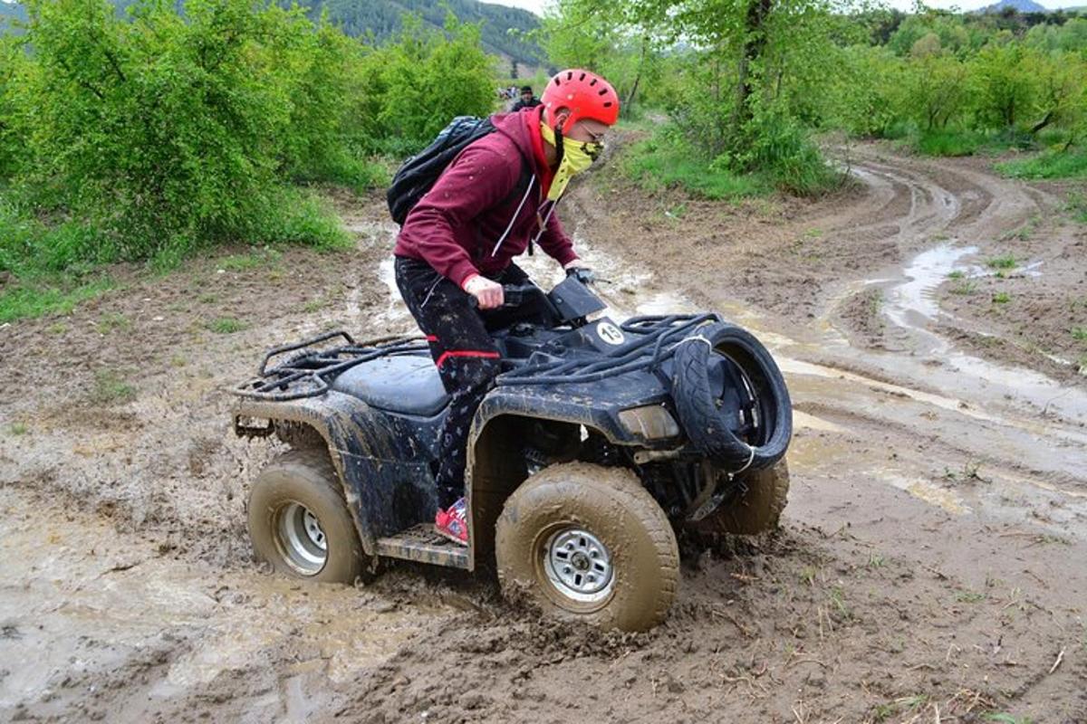 una persona che guida un veicolo a quattro ruote su una strada sterrata