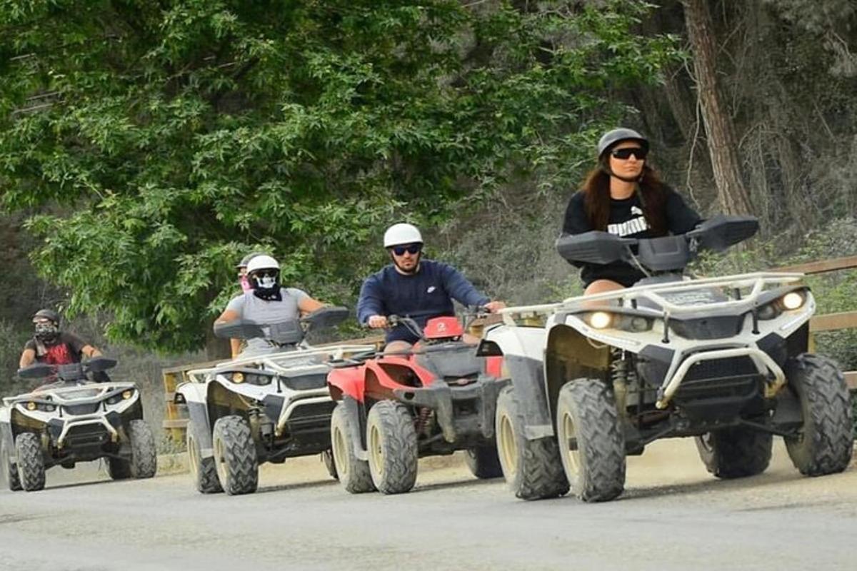 un gruppo di persone che guidano quad lungo una strada