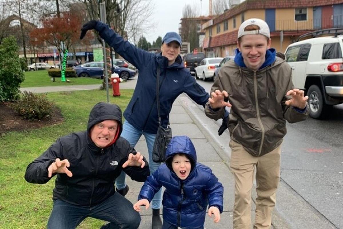 a group of people standing on a sidewalk with their arms out