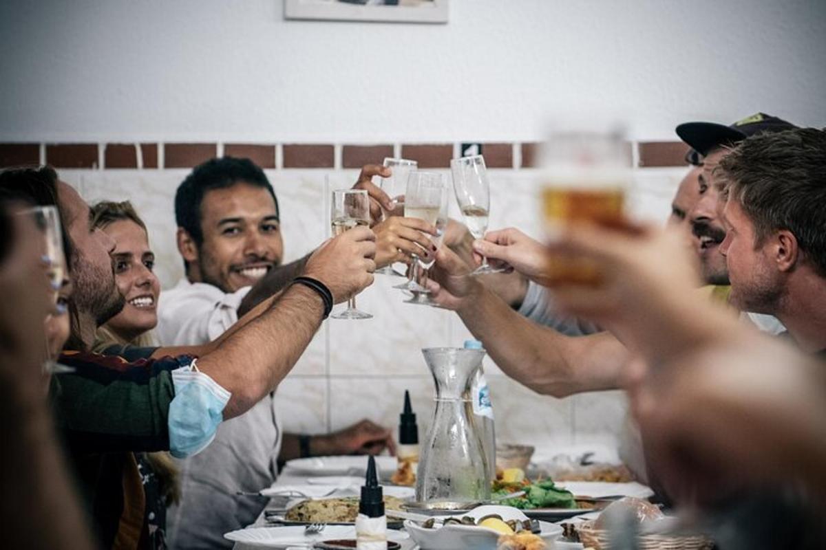 μια ομάδα ανθρώπων που κρατούν ψηλά ποτήρια κρασιού σε ένα τραπέζι