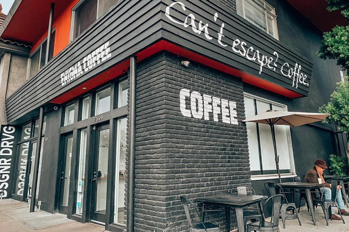 een vrouw die aan een tafel buiten een koffieshop zit