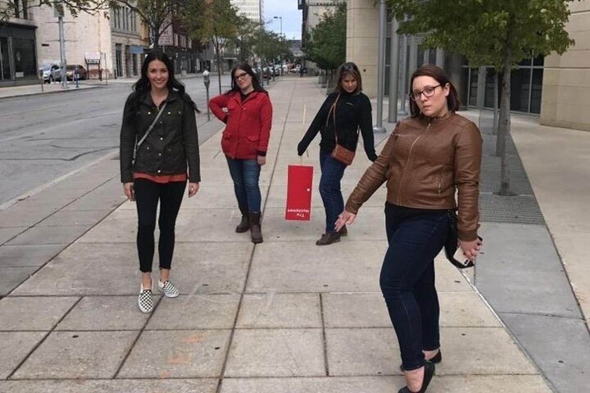 a group of women walking down a sidewalk