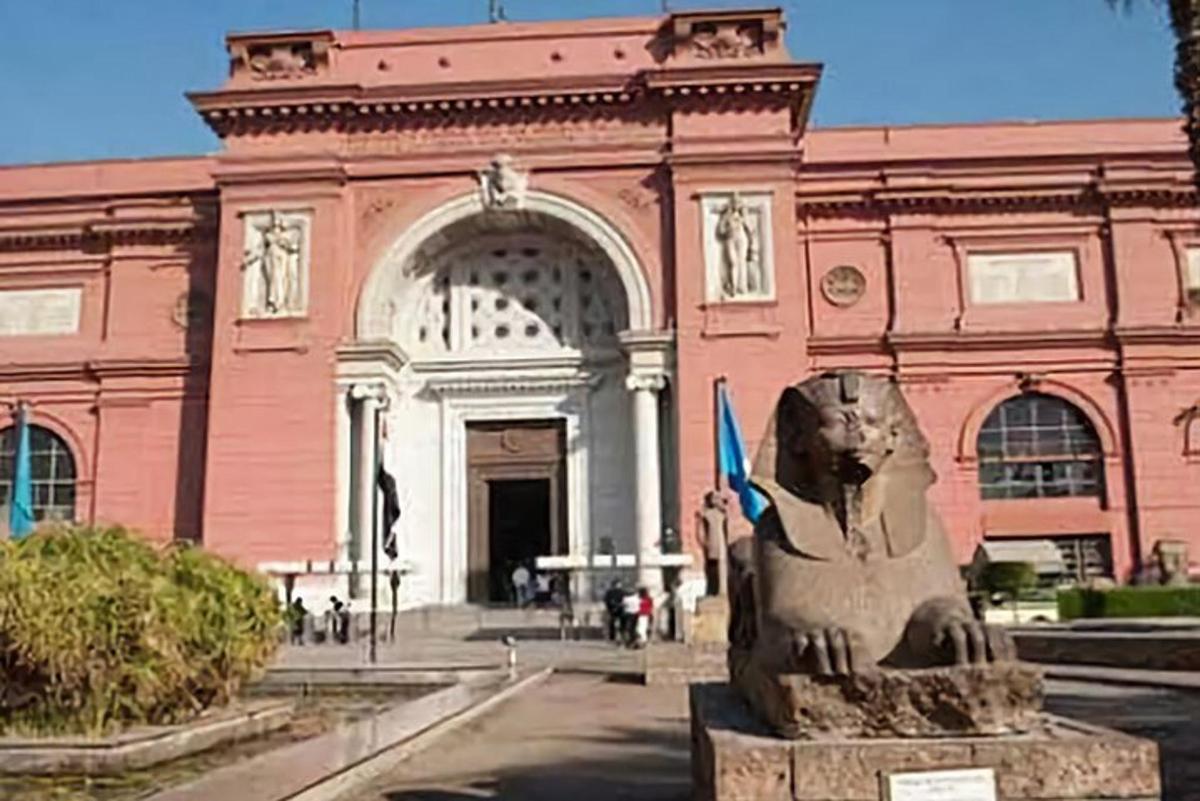 un grande edificio rosa con una statua di fronte